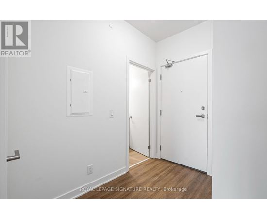 A white room with a door on the right and a window on the left.