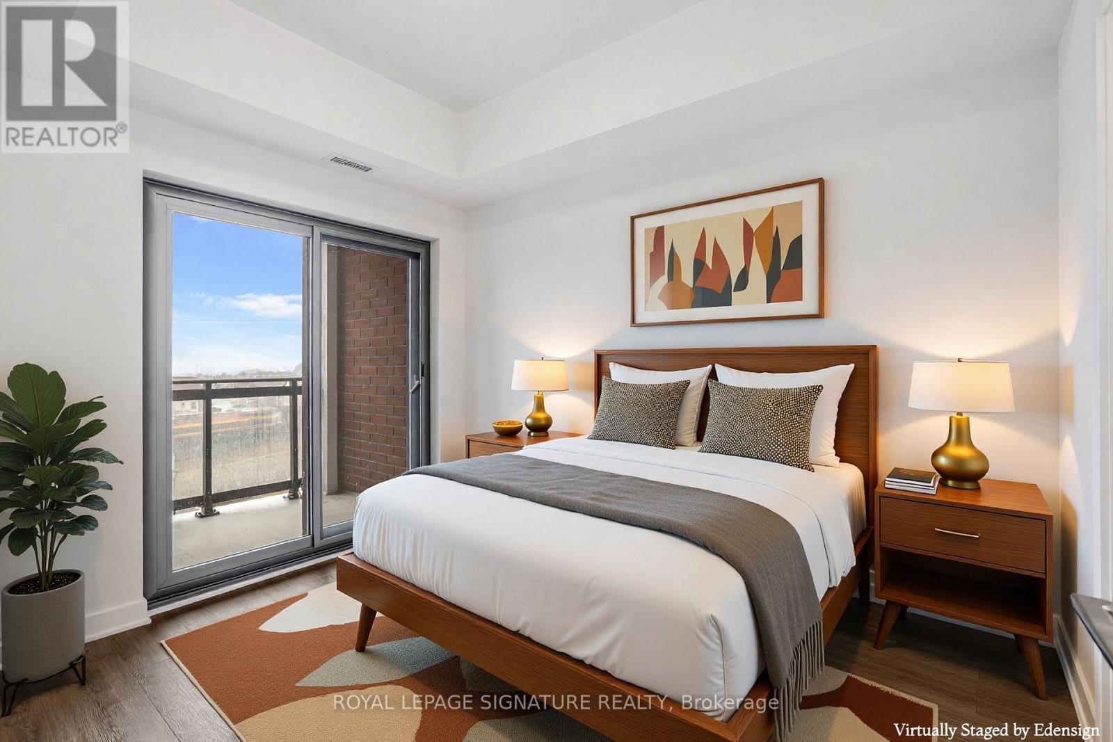 A bedroom with a large bed, a potted plant, and a painting on the wall.