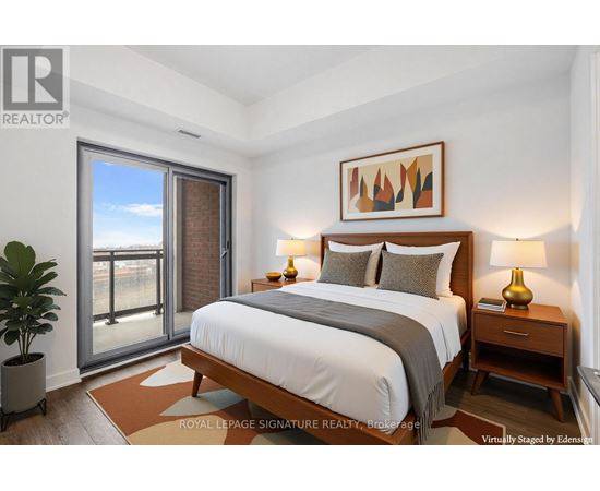 A bedroom with a large bed, a potted plant, and a painting on the wall.