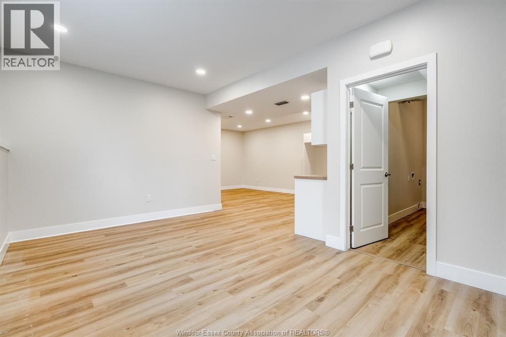 A room with wooden flooring and a white door.