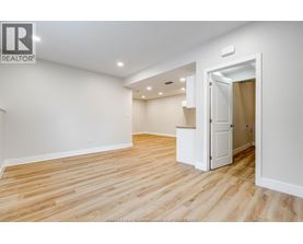 A room with wooden flooring and a white door.