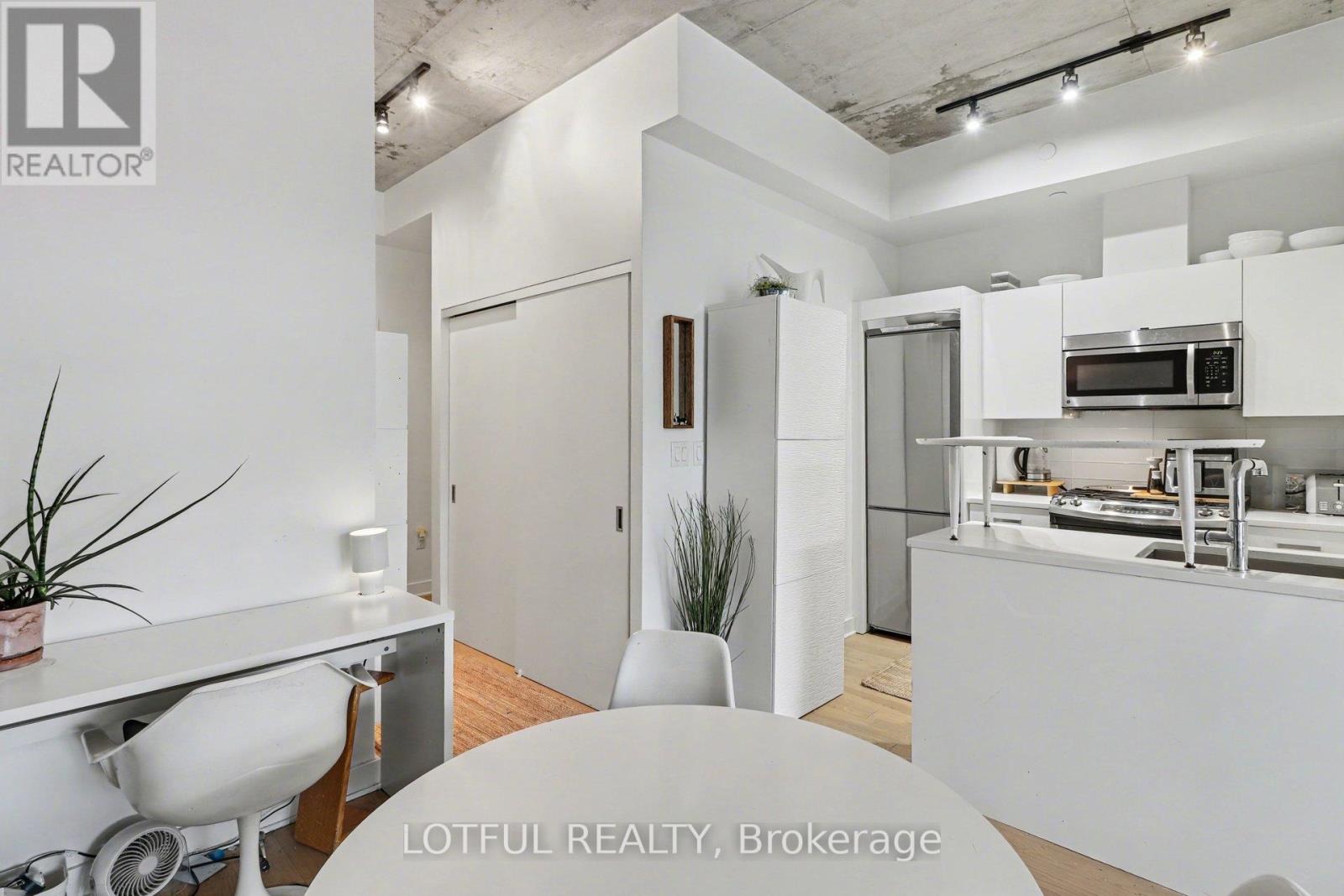 A white kitchen with a dining table and chairs.