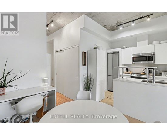 A white kitchen with a dining table and chairs.