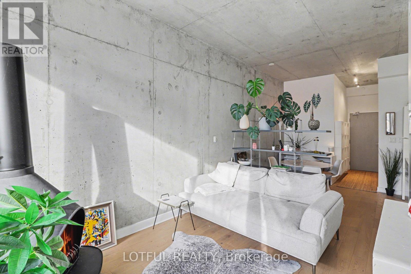 A living room with a white couch and a grey rug.