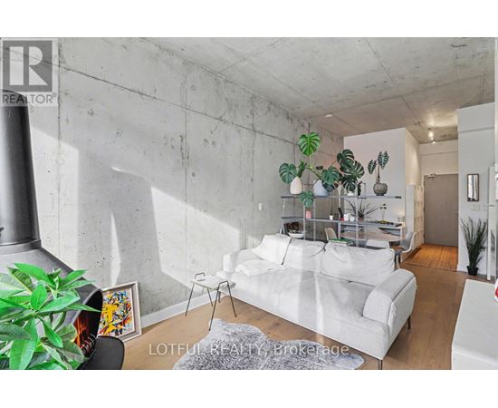 A living room with a white couch and a grey rug.