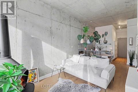 A living room with a white couch and a grey rug.