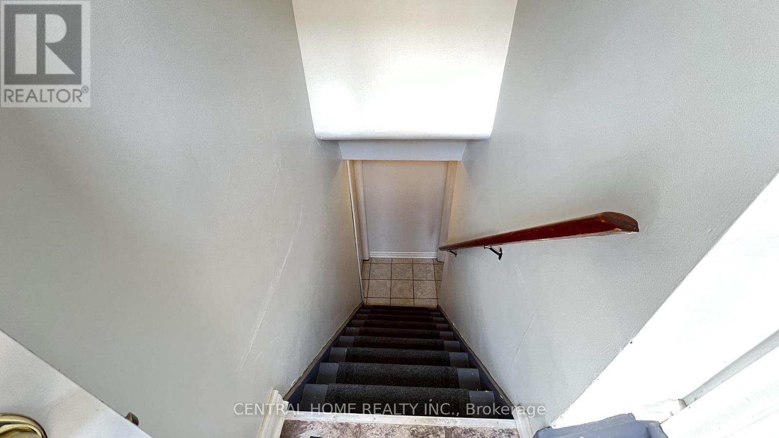 A staircase with a red handrail leads up to a doorway.
