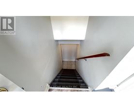 A staircase with a red handrail leads up to a doorway.