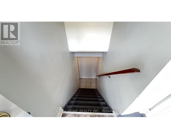 A staircase with a red handrail leads up to a doorway.