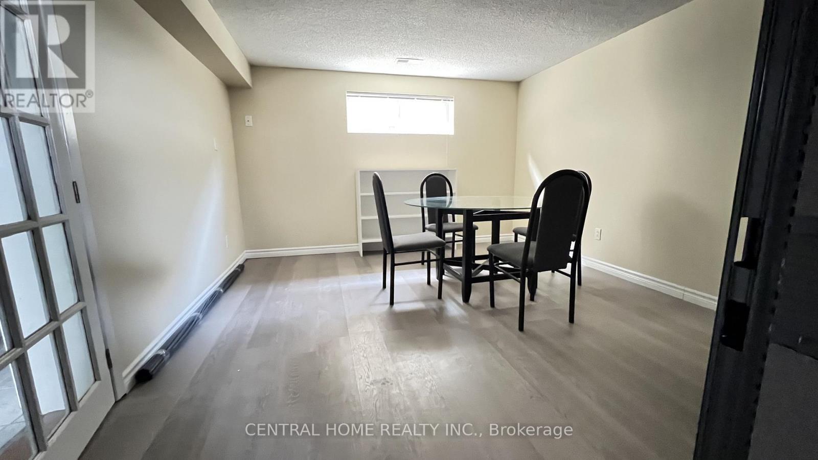 A dining room with a table and chairs.