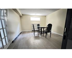 A dining room with a table and chairs.