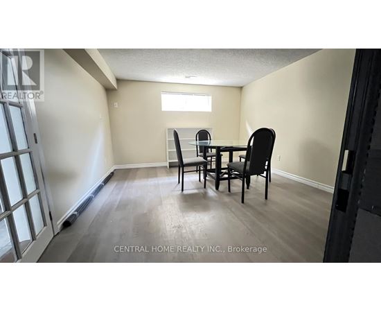 A dining room with a table and chairs.