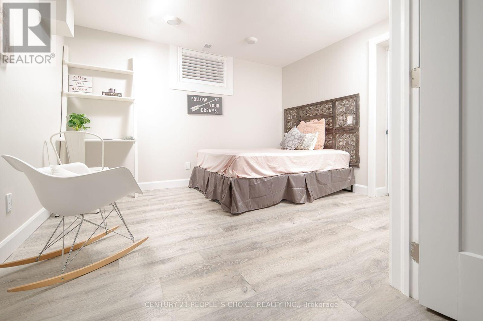 A bedroom with a bed, a chair, and a rocking chair.