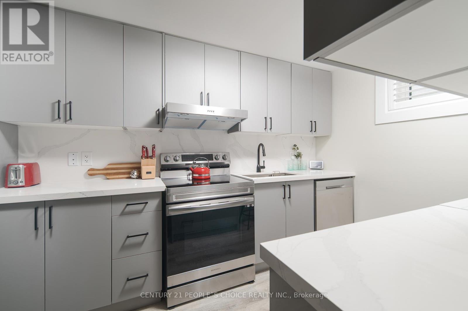 A modern kitchen with white cabinets and stainless steel appliances.