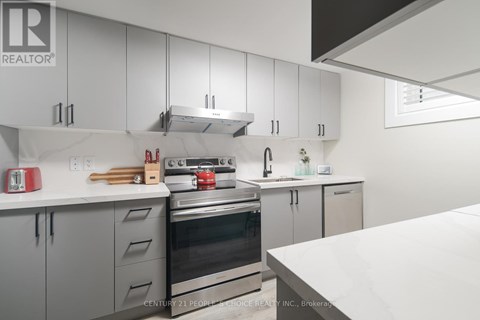 A modern kitchen with white cabinets and stainless steel appliances.