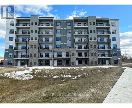 A large apartment building with a grassy area in front and a road leading to the entrance.
