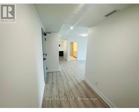 A hallway with wood flooring and white walls.