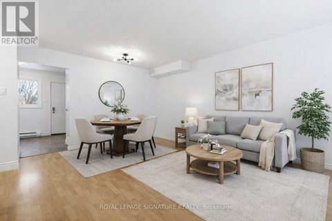 A well-lit, spacious living room with a dining table and a couch.