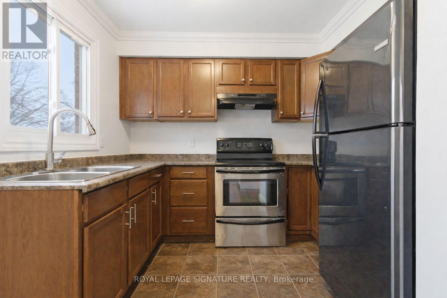 A kitchen with wooden cabinets and a stainless steel refrigerator.
