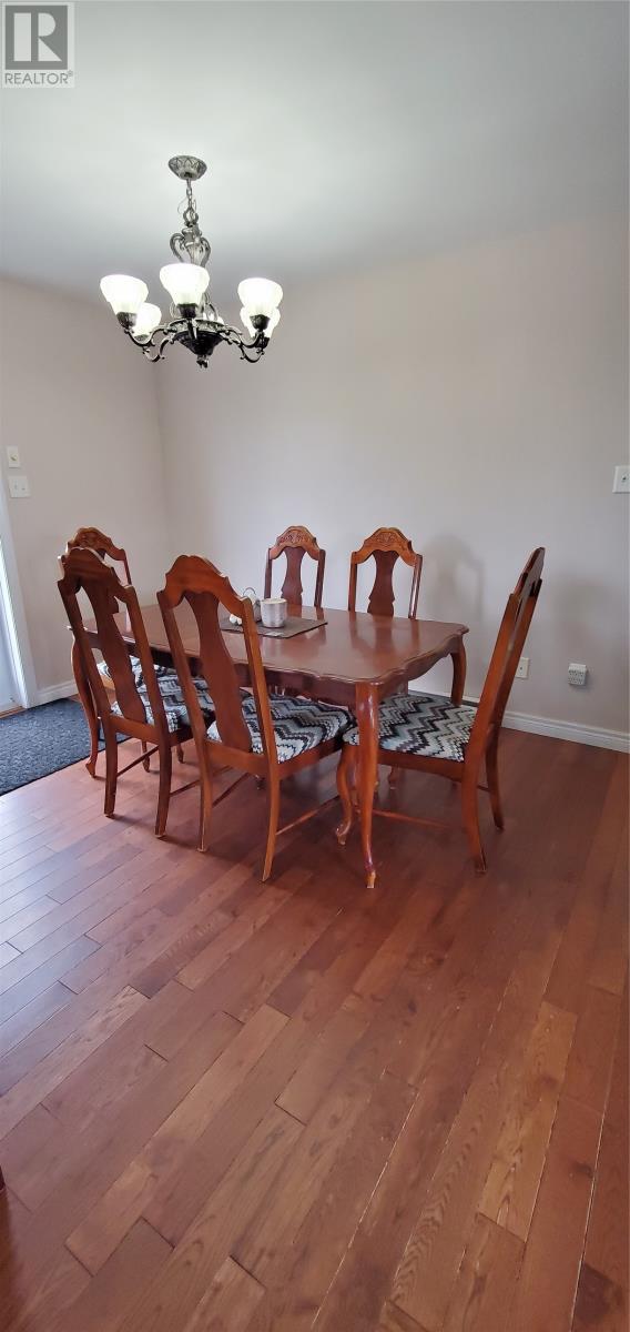 A dining room with a wooden table and chairs.