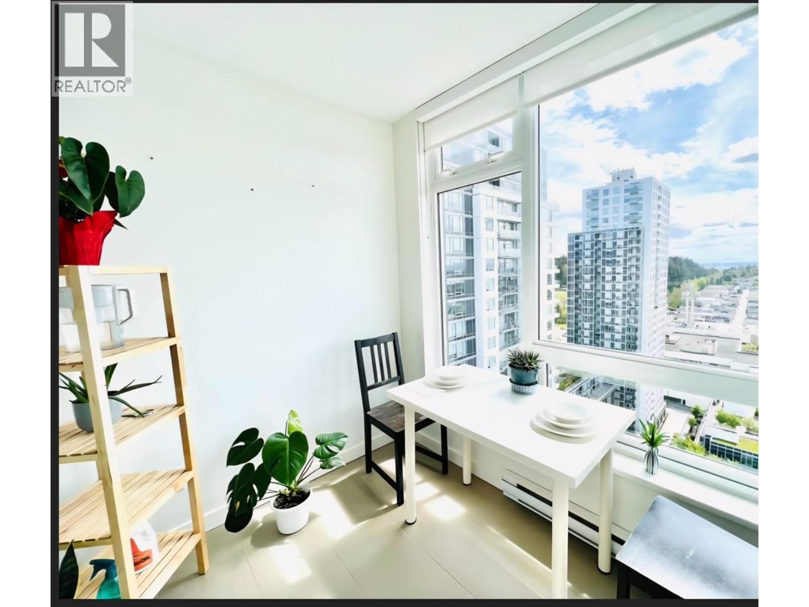 A small room with a table and chairs and a window with a view of a city.