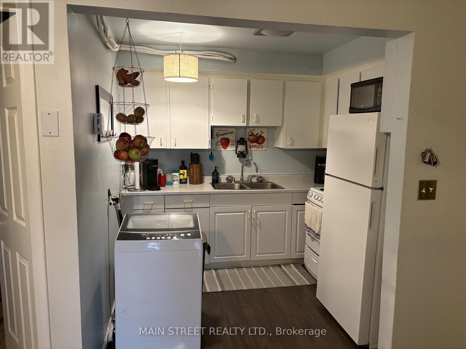 A kitchen with white appliances and cabinets.