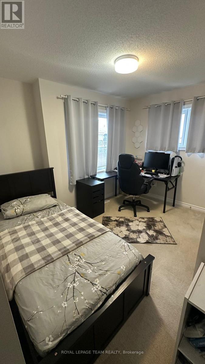A bedroom with a bed, desk, and chair.