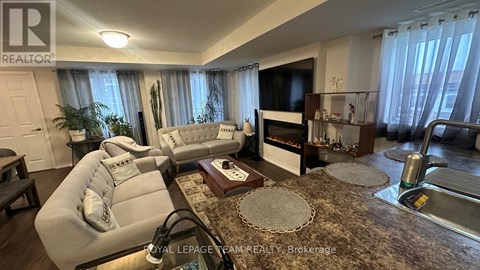 A living room with a white couch and a rug.