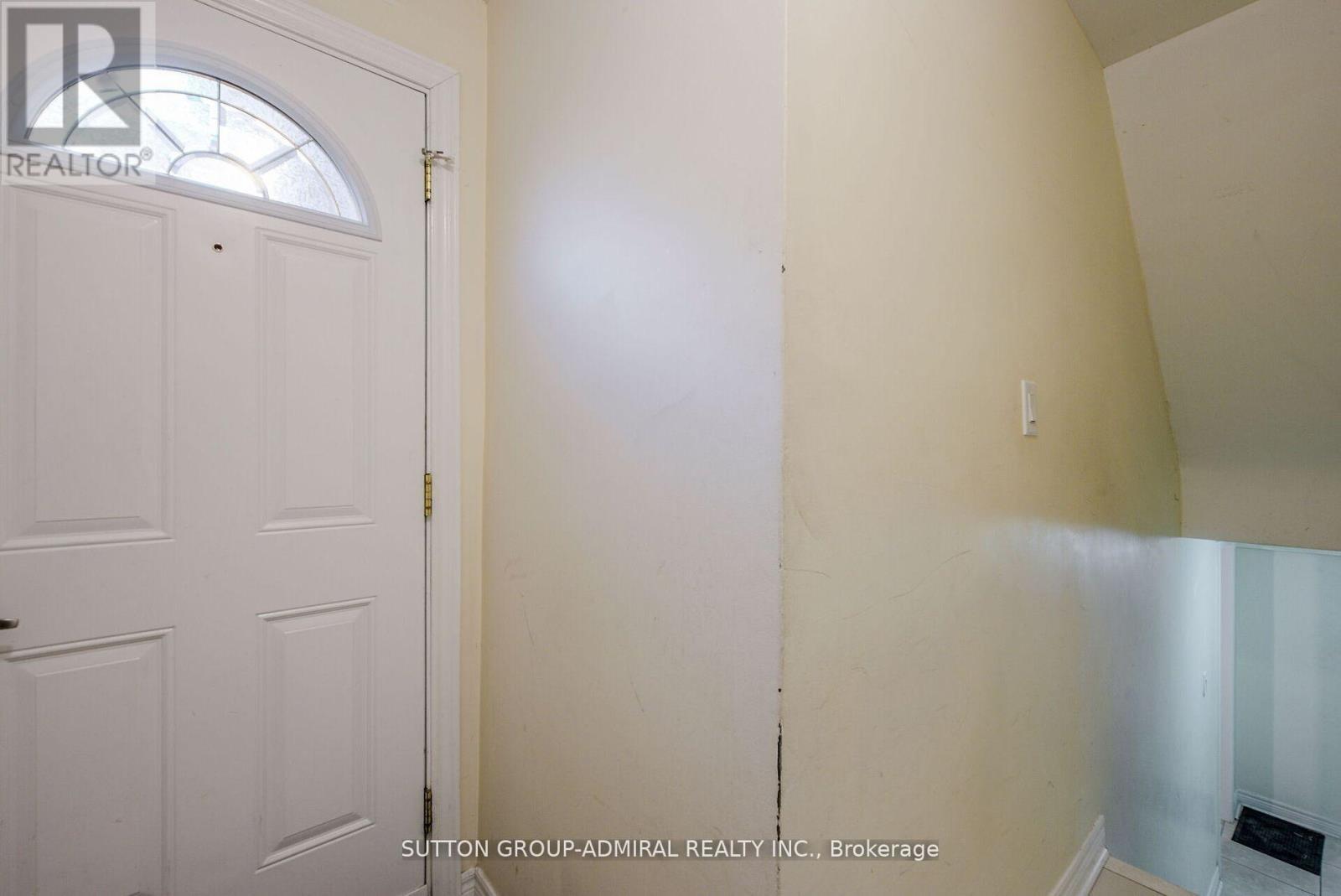 A white door with a window above it in a room.