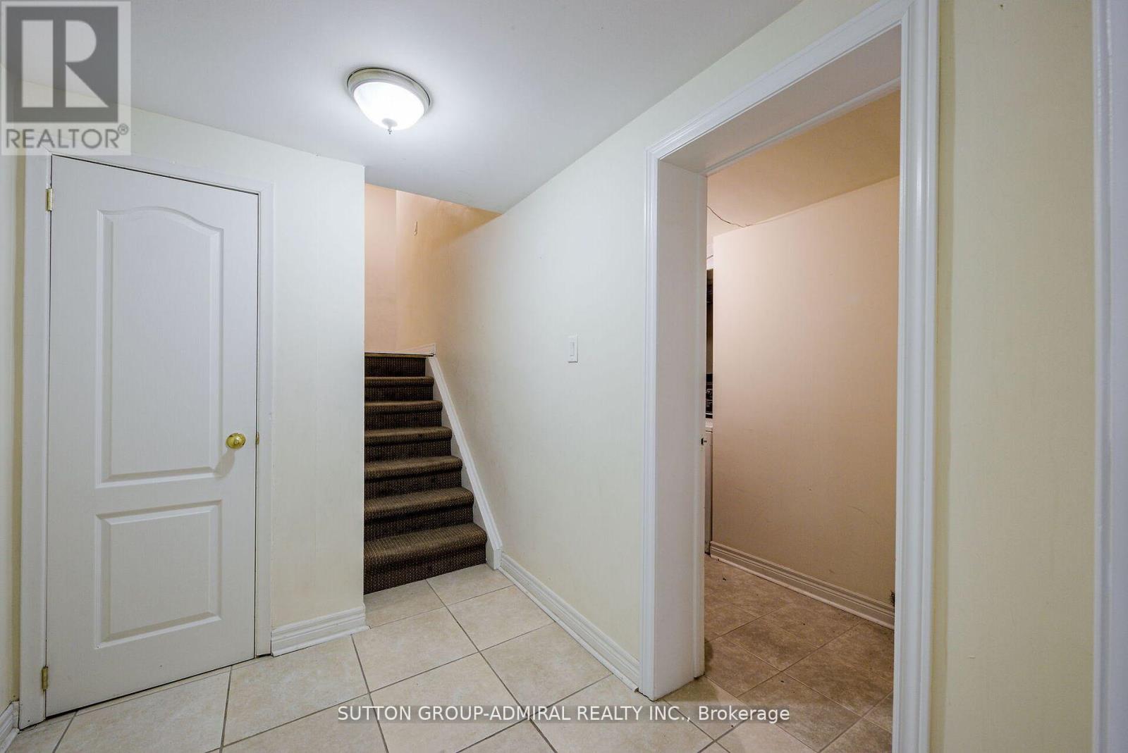 A hallway with a white door and a staircase.