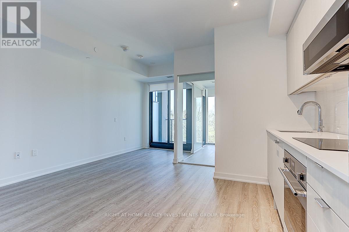 A spacious kitchen with white cabinets and a sink.