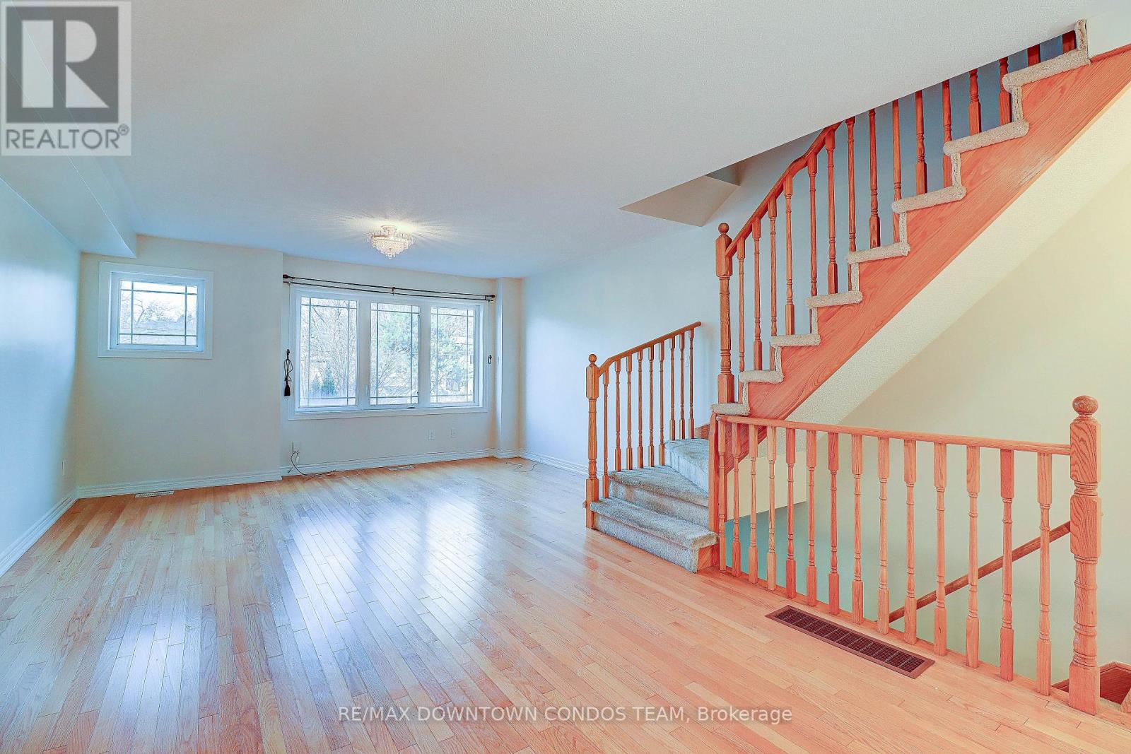 A spacious room with a staircase leading to the upper floor.