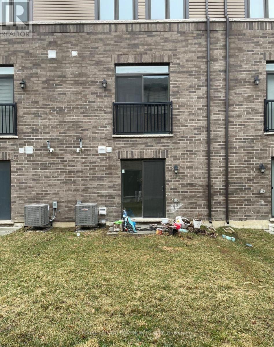A building with a balcony and a door is in front of a grassy area.