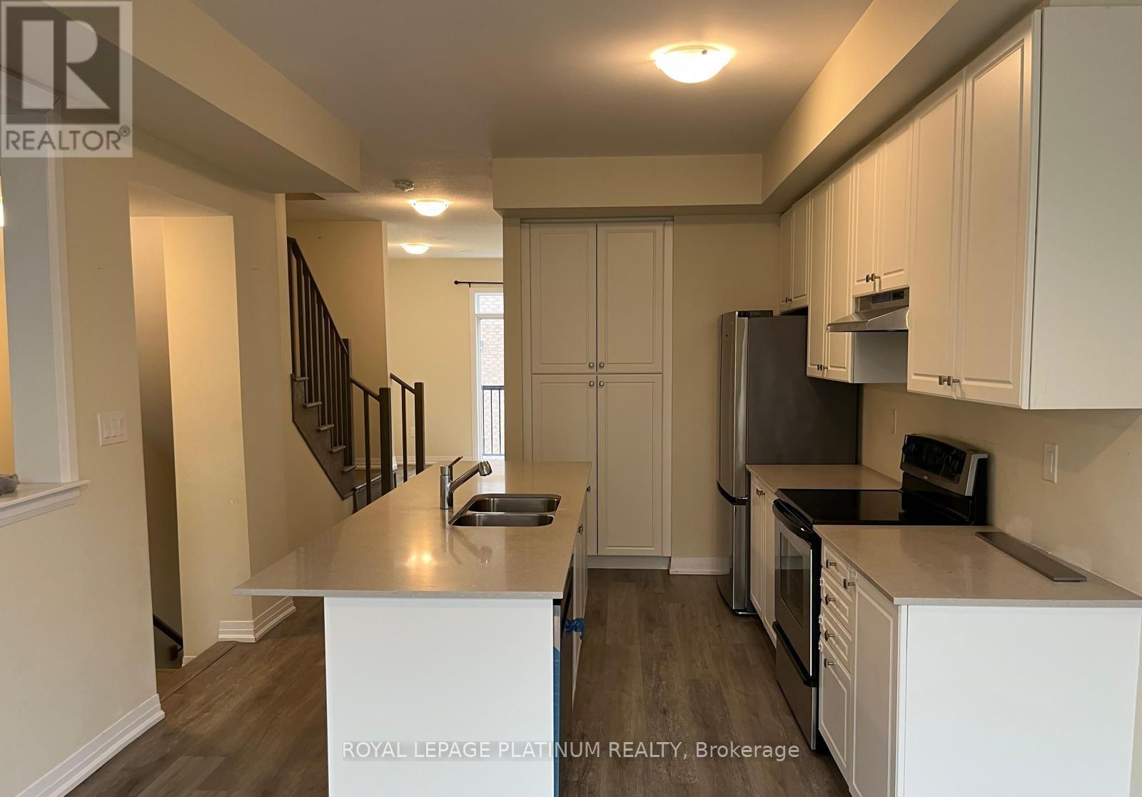 A kitchen with white cabinets and a stainless steel refrigerator.
