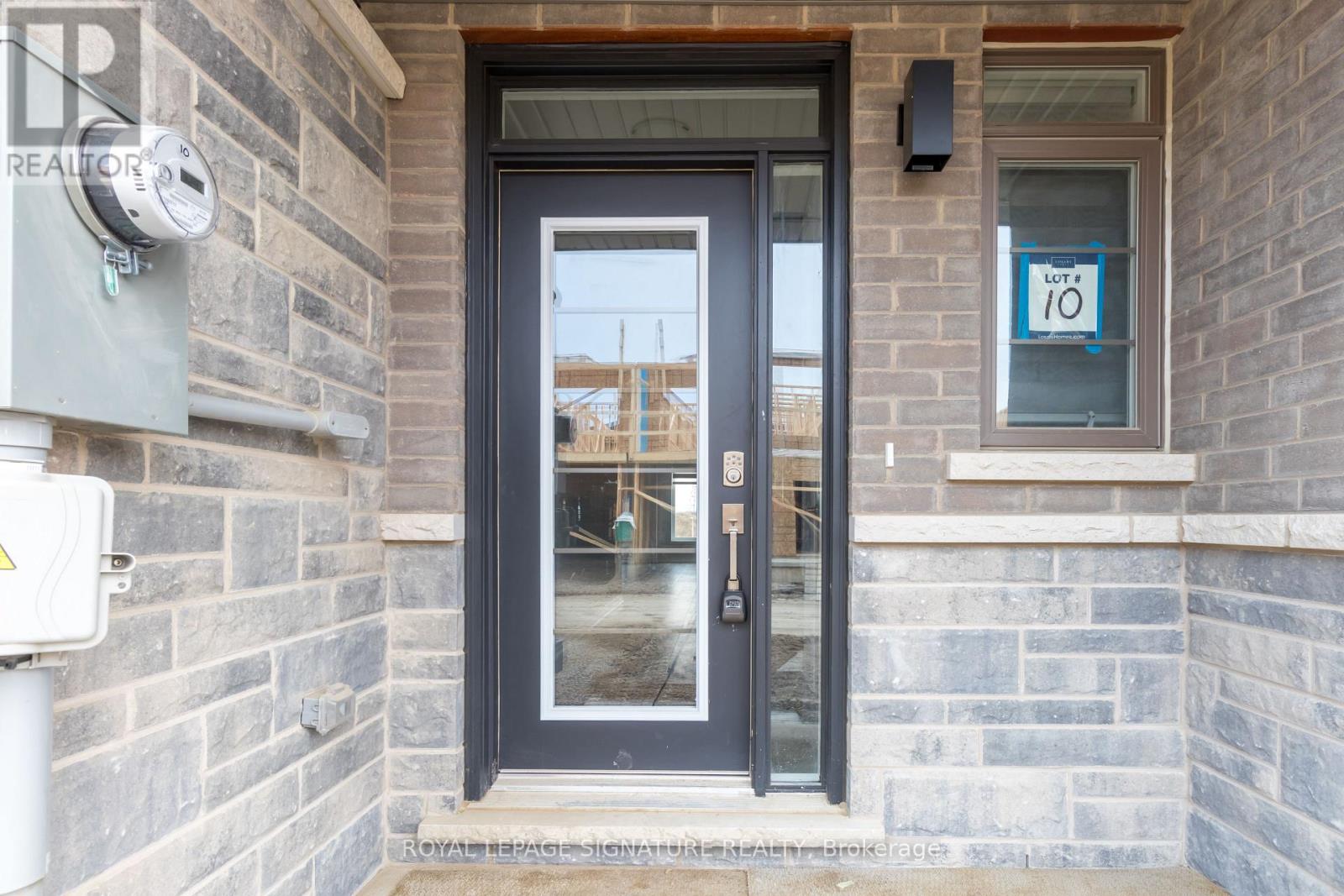 A black door with a glass window is on the front of a building.