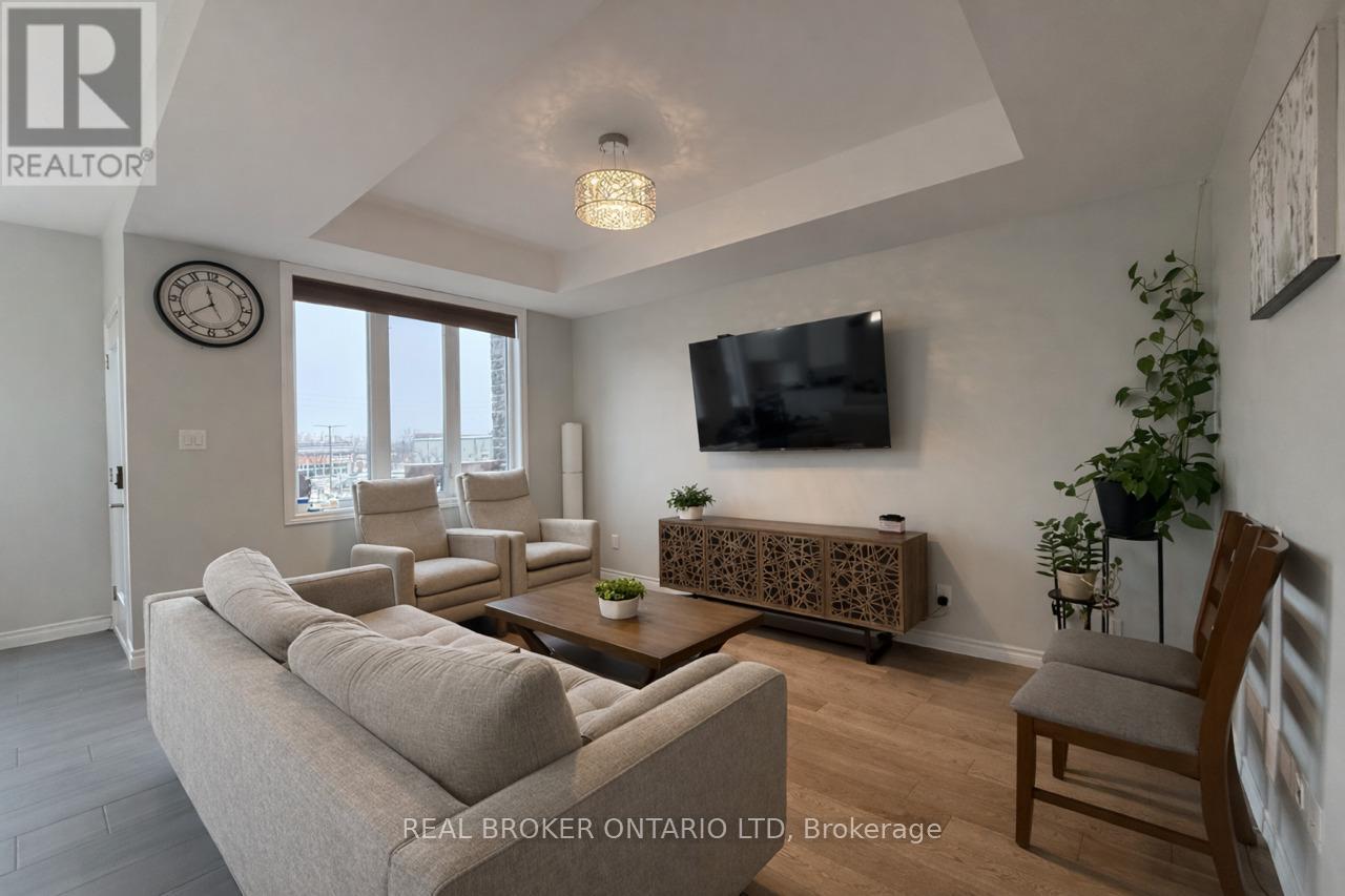 A living room with a grey couch, a wooden coffee table, a flat screen TV, and a large window.