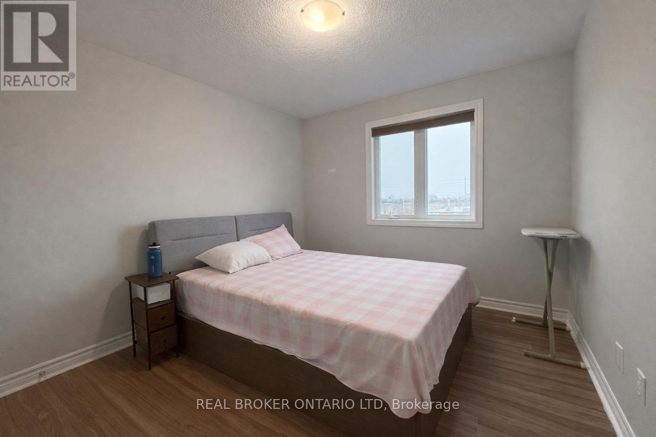 A bedroom with a bed, nightstand, and window.
