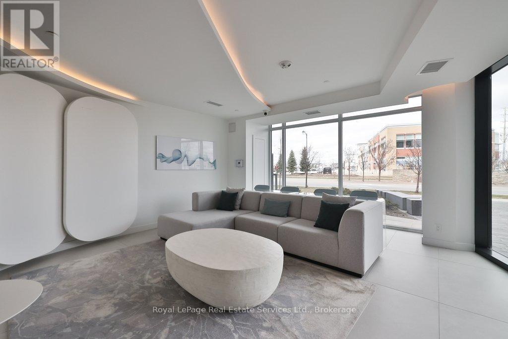A modern living room with a grey sofa and a large window.