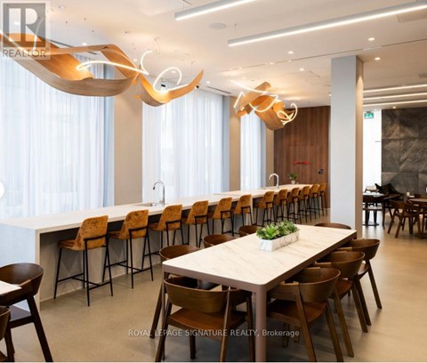 A modern dining room with a long table and chairs.