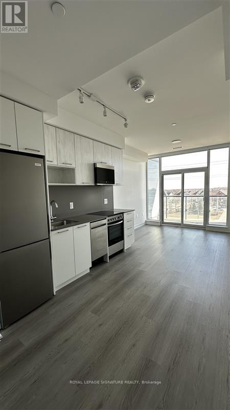 A modern kitchen with a refrigerator, cabinets, and a countertop.