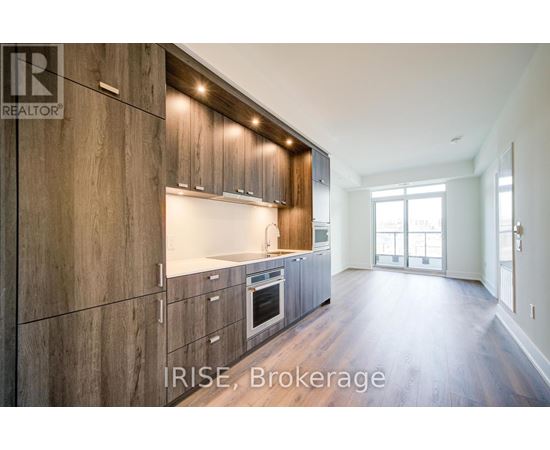 A modern kitchen with wooden cabinets and a large window.