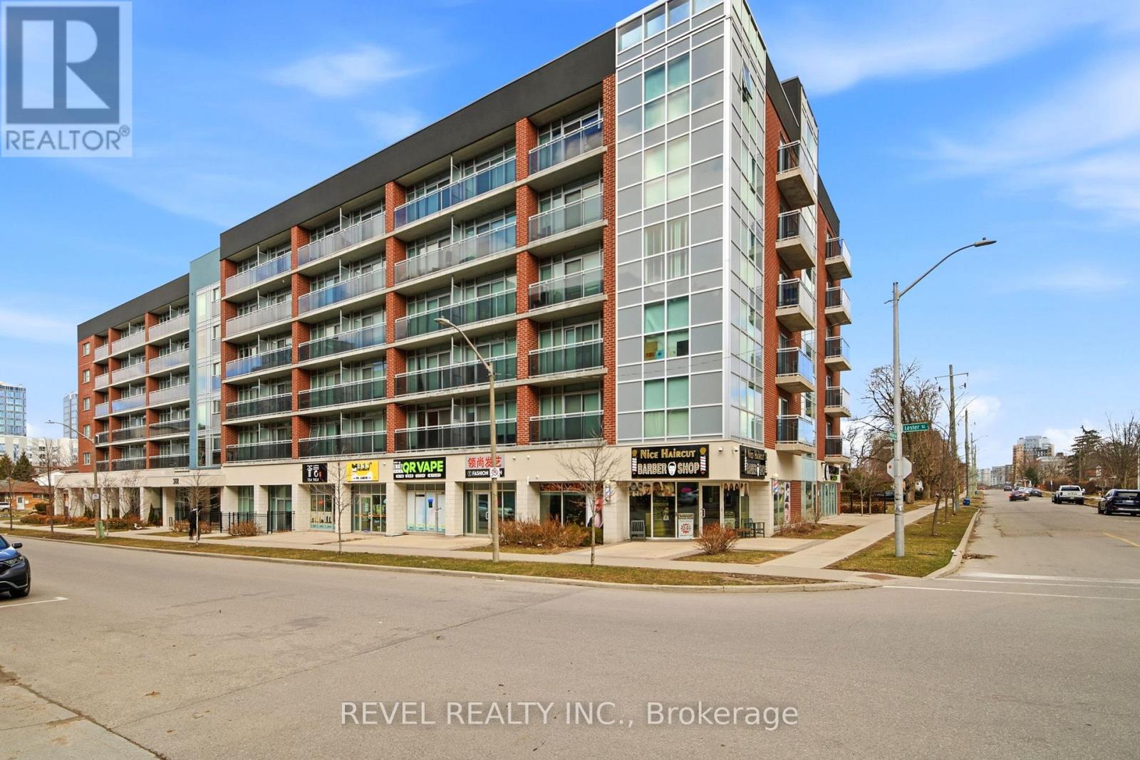 A multi-story building with a sign that reads "REVEL REALTY INC., Brokerage" in front of it.