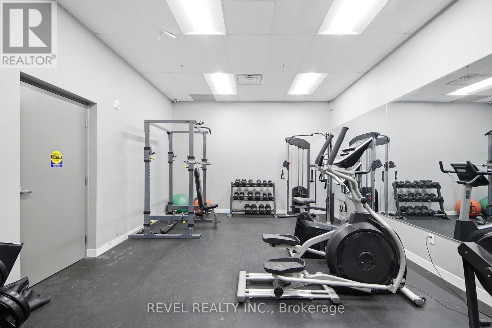 A gym with a variety of equipment including weights and cardio machines.