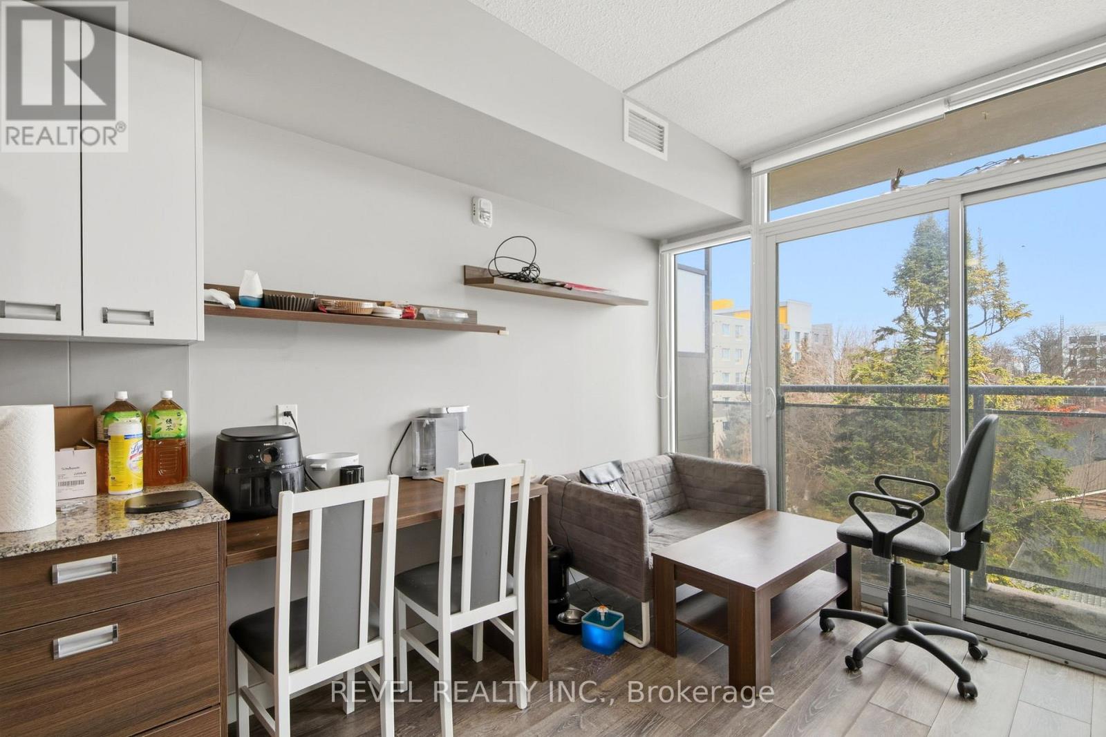 A kitchen with white cabinets and a counter with a toaster and a bottle of oil.