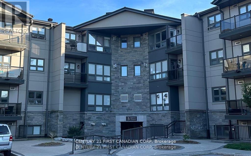 A large apartment complex with a stone facade and balconies.