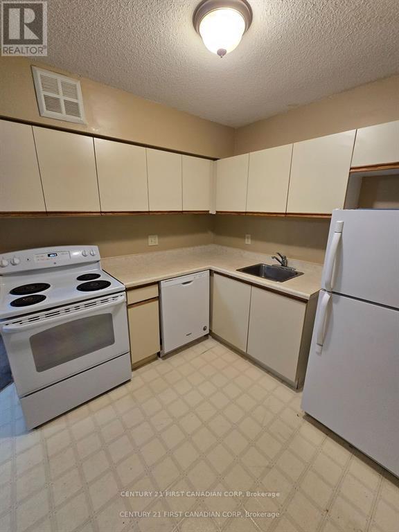 A kitchen with white appliances and brown cabinets.