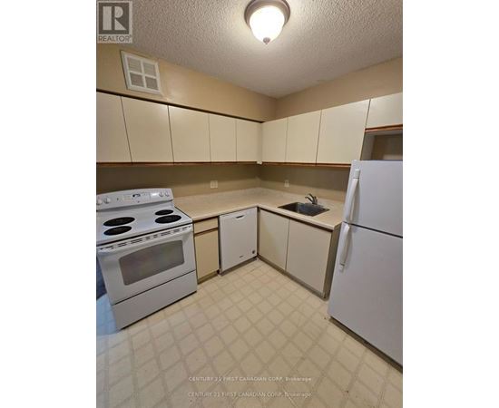 A kitchen with white appliances and brown cabinets.
