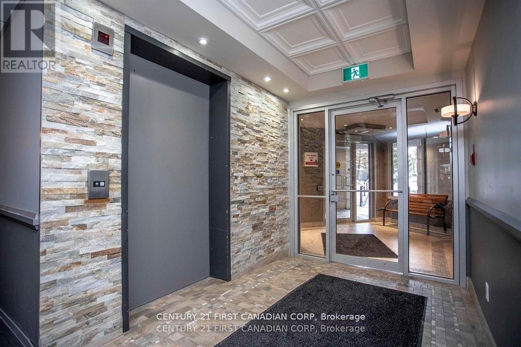 A brokerage office entrance with a stone wall and glass doors.