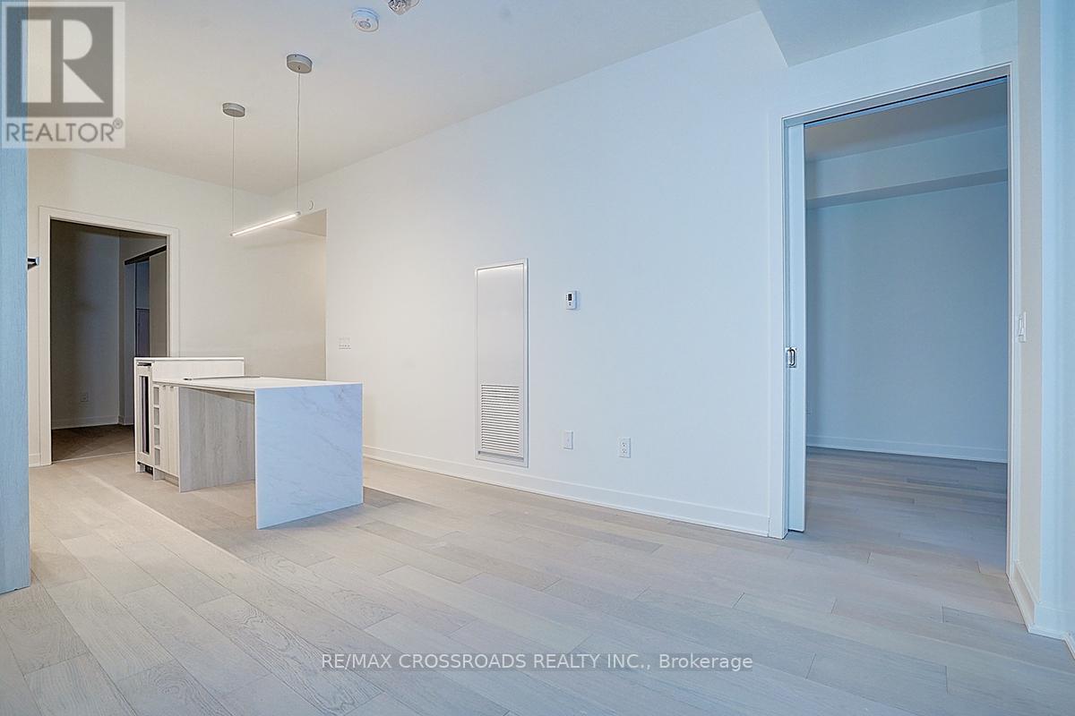 A spacious room with a white cabinet and a door on the right side.