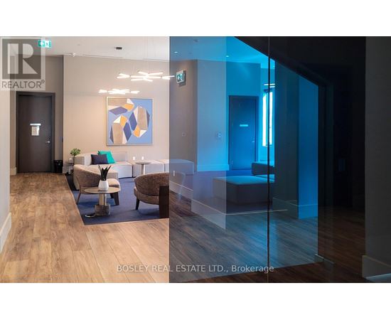 A modern office space with a glass wall and a wooden floor.